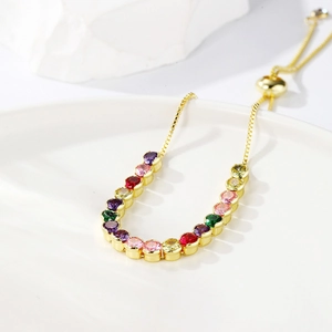 Detail of adjustable gold box chain bracelet featuring vibrant multi-color zircon stones