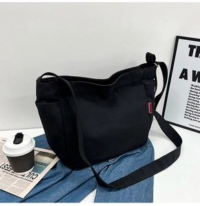 Detail of black canvas tote bag showing large capacity and street style design