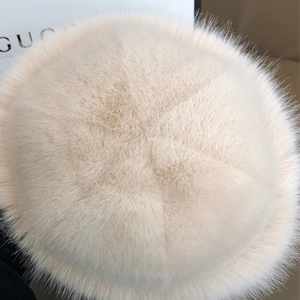 Detailed close-up of fluffy faux mink fur texture on a cream white plush bucket hat