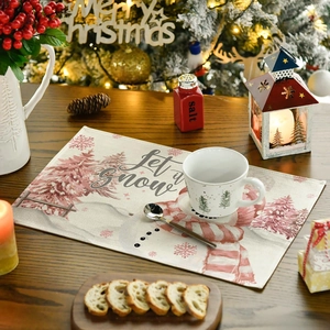 Detailed linen texture of Christmas placemat featuring snowman and Let it Snow print