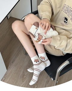 Detailed view of cream cotton socks with brown stripes and cute capybara pattern