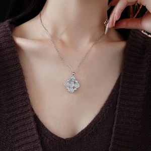 Gros plan d'un collier trèfle à quatre feuilles en argent avec zircons sur un mannequin