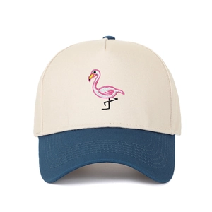 Detail der Flamingo-Stickerei auf einer zweifarbigen beige-blauen Baseballkappe