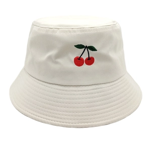 Close-up of cherry embroidery and cotton twill texture on a beige bucket hat