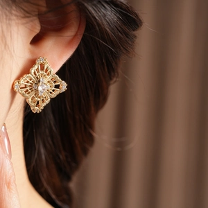 Detail shot of hollow flower earrings with gold plating and sparkling zircon stones