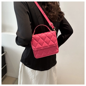Vue latérale d'un sac à bandoulière matelassé rose porté par un mannequin pour la taille