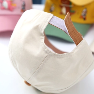 Close-up of adjustable velcro strap and stitching on kids' cream baseball cap