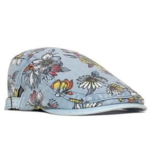 Detail of light blue denim flat cap featuring colorful floral prints and metal side buckle