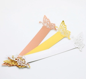 Close-up of laser-cut butterfly napkin rings in gold, pink gold, and white cardstock