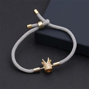Détail du bracelet en corde de Milan grise avec breloque couronne dorée et zircons