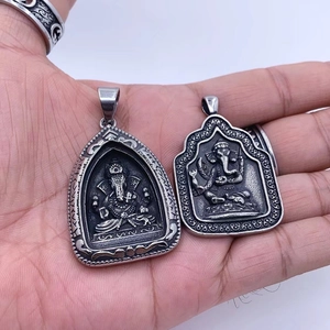 Macro detail of retro Ganesha pendants in silver-gray stainless steel with vintage finish