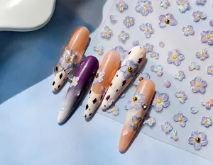 Close-up of 3D purple floral nail stickers with holographic details on sheet