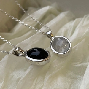 S925 sterling silver oval necklaces with black agate and moonstone pendants on white paper