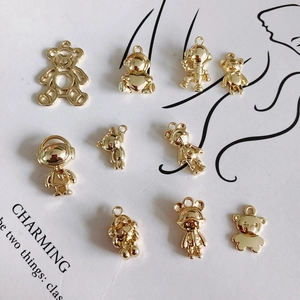 Golden alloy bear and astronaut charms for DIY jewelry making on decorative paper