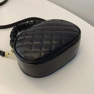 Detailed view of the black quilted rhombic texture on a stylish leather crossbody bag