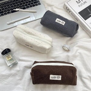 Minimalist wool polka dot pencil cases in grey, cream, and brown with zipper closure
