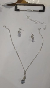 Detail view of silver bridal jewelry set with zircon flowers and lavender waterdrop stones