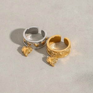 Macro shot of silver and gold open rings featuring relief hearts and dangling heart charms