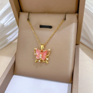 Detailed macro view of pink hollow butterfly pendant with zircon inlay in jewelry box