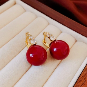 Gros plan de boucles d'oreilles rétro avec perles rouges et détails dorés sertis de zircons