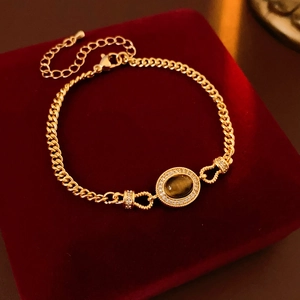 Detailed shot of a gold-plated tiger eye bracelet on a red velvet jewelry gift box
