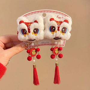 Detailed view of Chinese New Year lion dance hair clips with red tassels and fur balls