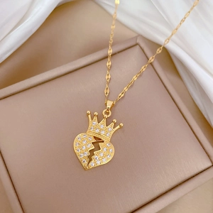Elegant gold crown and broken heart necklace with sparkling crystals in a jewelry box