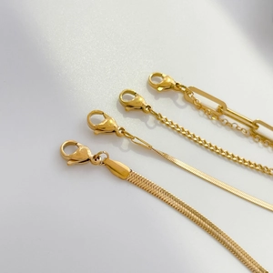Detailed close-up of four assorted gold-tone metal chains with secure lobster claw clasps