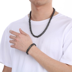 Close-up of black stainless steel Byzantine chain necklace and bracelet set on a model