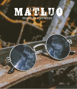 Detailed view of silver metal bridge with intricate carvings on vintage round sunglasses