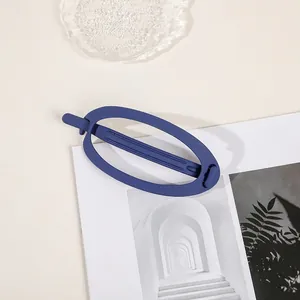 Detail of matte navy blue large hair clip on a minimalist lifestyle magazine layout