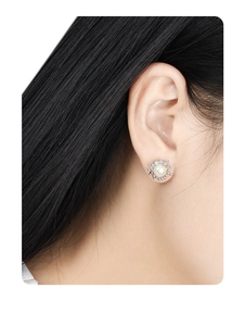 Detailed view of irregular silver lava earring with white pearl on model ear