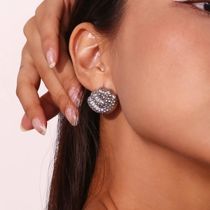 Detail of vintage silver stud earring with hammered texture and multi-layer fan design