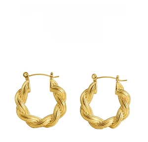 Détail macro de boucles d'oreilles torsadées en plaqué or avec un design minimaliste en U