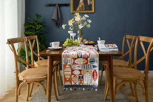 Close-up of colorful jacquard table runner with fish patterns and fringe tassels