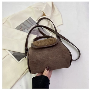 Detail of dark brown faux suede handbag with plush trim and silver hardware details