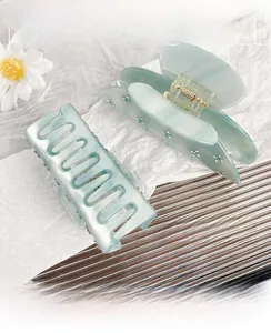 Detail of light blue acetate hair claw clips with rhinestones and floral accents