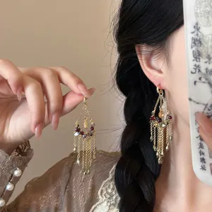 Macro detail of vintage gold hoop earrings with colorful bead tassels and chain fringe