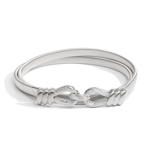 Detail of silver elastic waist belt featuring a decorative knot-shaped metal buckle