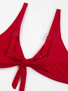 Dettaglio del top bikini rosso con fiocco frontale e spalline regolabili in metallo