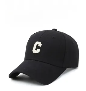 Detail of the white embroidered letter C on a black cotton twill baseball cap
