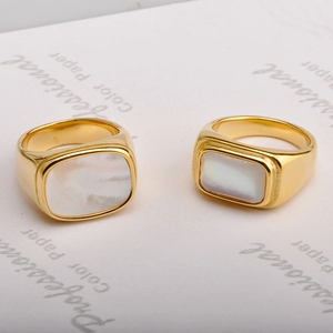 Polished gold square stainless steel rings with white shell inlays on white card