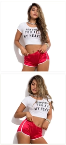 Detail of red satin sports shorts with white trim and cropped graphic T-shirt set