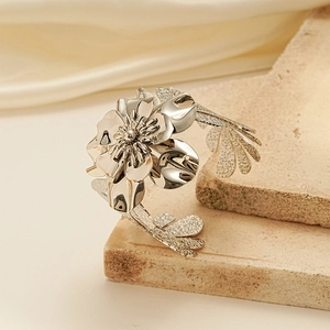 Elegant silver metal flower cuff bracelet with polished petals on natural stone