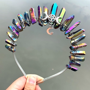 Detail of colorful crystal crown with moon pendant and star charms on metal headband