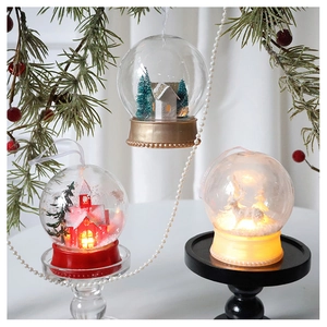 Detailed close-up of LED Christmas ornaments featuring a mini house and deer in snow