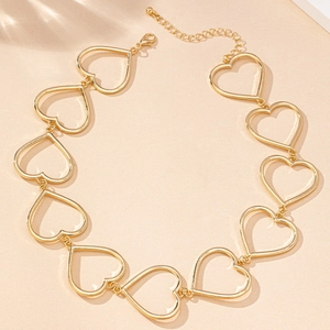 Detailed close-up of golden hollow heart pendants necklace with lobster clasp and chain