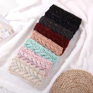 Close-up of cable knit headbands in various colors with colorful speckled yarn texture