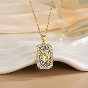 Detailed macro view of a gold dolphin tarot necklace with blue enamel and pavé crystals