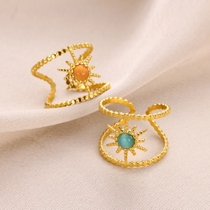 Close-up of gold double-row beaded rings with sunburst turquoise and orange stone settings
